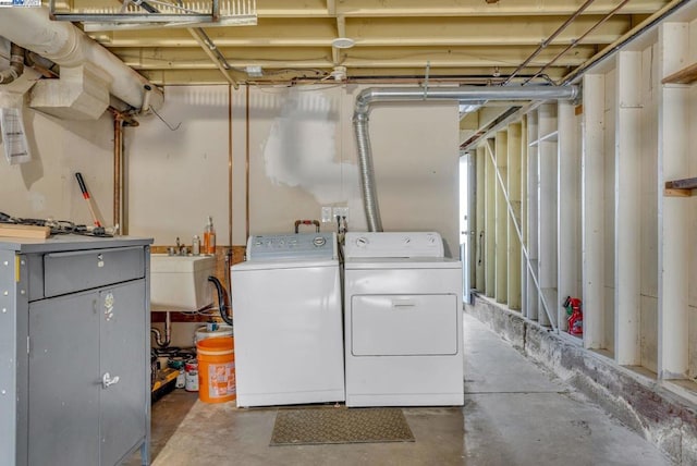 laundry area with separate washer and dryer and sink