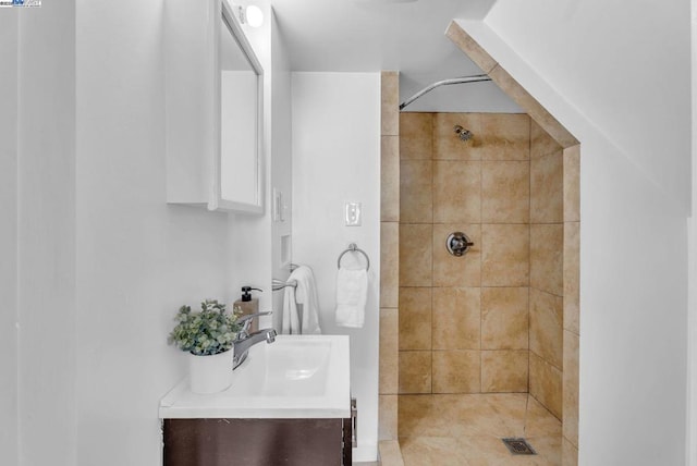 bathroom with vanity and a tile shower