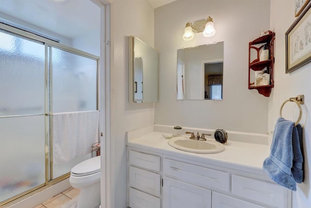 bathroom with vanity, toilet, an enclosed shower, and tile patterned flooring