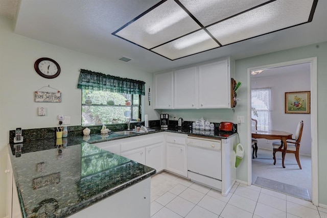 kitchen with sink, light tile patterned floors, dishwasher, white cabinetry, and dark stone countertops