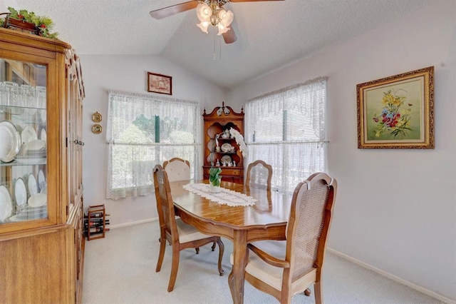 carpeted dining room with ceiling fan, vaulted ceiling, and a textured ceiling