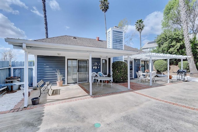 rear view of property featuring a patio and a pergola