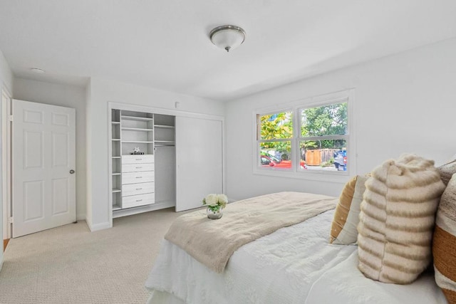 bedroom with light carpet and a closet