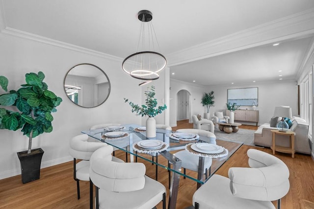 dining space featuring crown molding, a chandelier, and light wood-type flooring