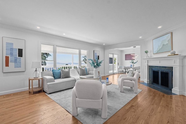 living room with crown molding and light hardwood / wood-style floors