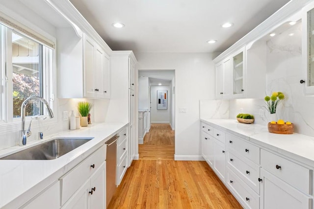 kitchen with backsplash, sink, light hardwood / wood-style flooring, and white cabinets