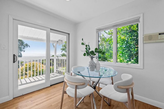 dining area featuring light hardwood / wood-style floors and a wall mounted AC