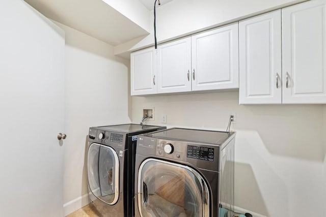 laundry area featuring separate washer and dryer and cabinets