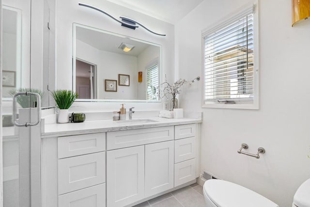 bathroom featuring vanity, tile patterned floors, and toilet