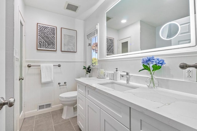 bathroom with tile patterned flooring, vanity, and toilet