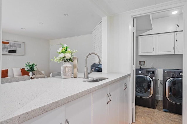 laundry room featuring sink, cabinets, and washing machine and clothes dryer