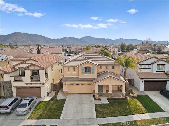 view of front of home featuring a garage, a mountain view, and a front lawn