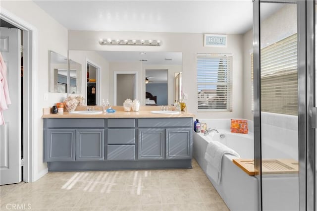 bathroom with vanity, tiled bath, and tile patterned floors