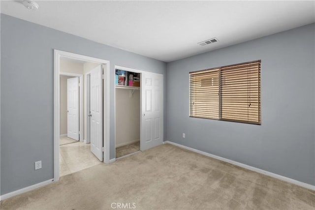 unfurnished bedroom featuring light colored carpet and a closet