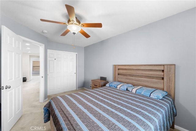 bedroom featuring light carpet, a closet, and ceiling fan