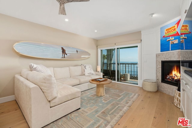 living room with a water view and light hardwood / wood-style flooring