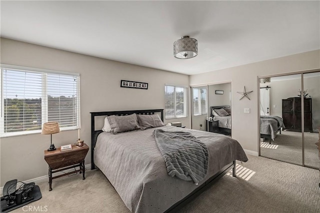 carpeted bedroom featuring multiple closets and multiple windows