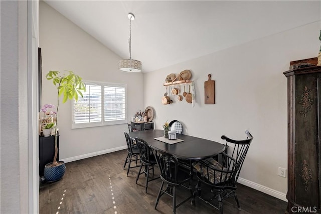 dining space featuring dark hardwood / wood-style flooring and vaulted ceiling