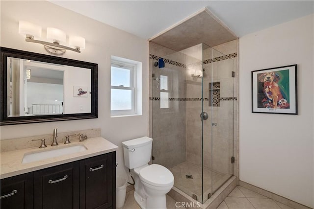 bathroom featuring tile patterned flooring, vanity, an enclosed shower, and toilet