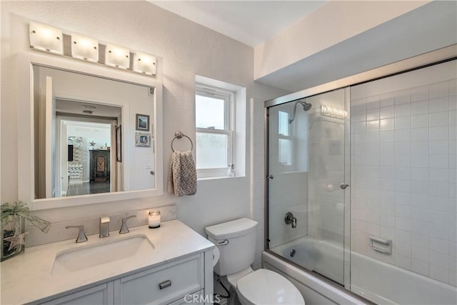 full bathroom with vanity, toilet, and bath / shower combo with glass door