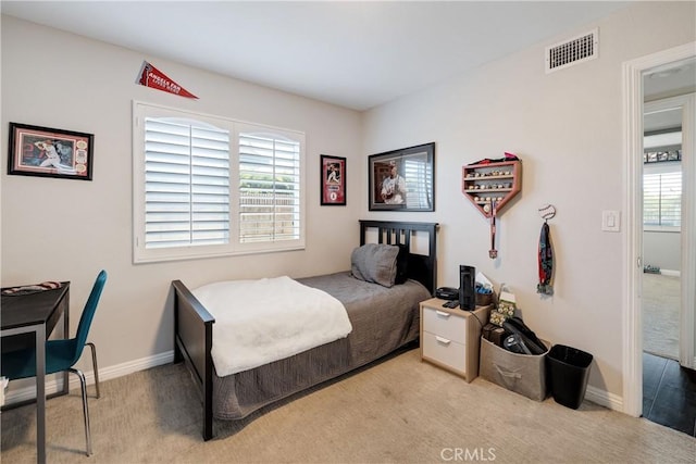 bedroom featuring multiple windows and light colored carpet