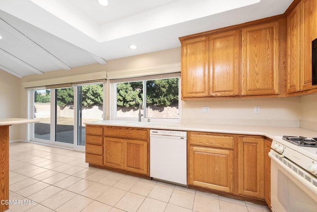 kitchen with vaulted ceiling, white appliances, sink, and light tile patterned floors