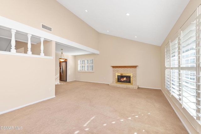 unfurnished living room with a fireplace, high vaulted ceiling, and light carpet