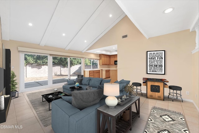 tiled living room featuring beam ceiling and high vaulted ceiling