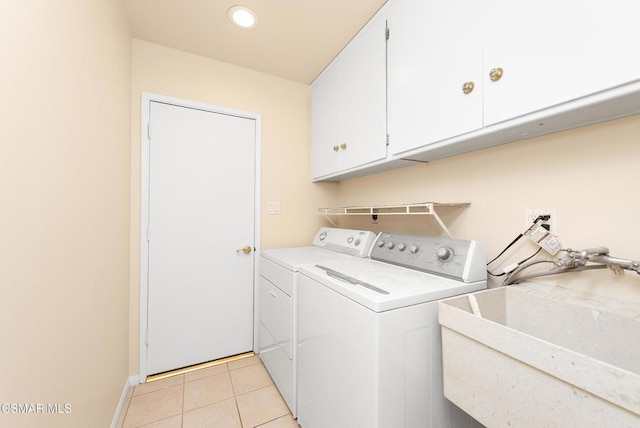 washroom featuring light tile patterned flooring, cabinets, sink, and washing machine and dryer