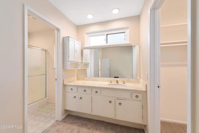 bathroom with a shower with door and vanity