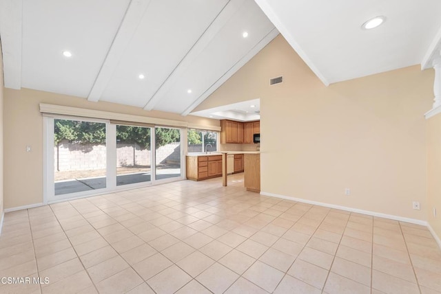 unfurnished living room featuring light tile patterned floors, high vaulted ceiling, sink, and beamed ceiling