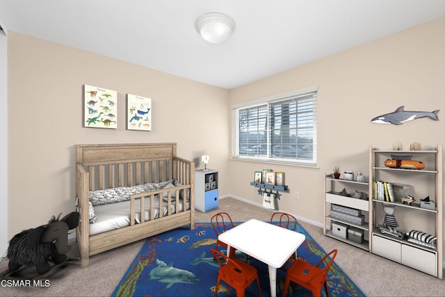 bedroom featuring a nursery area and carpet flooring