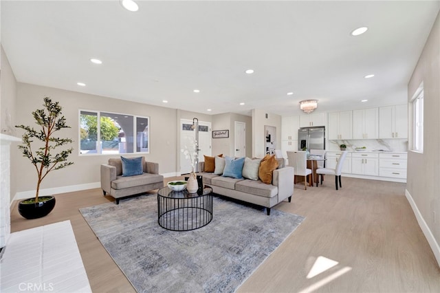 living room featuring light wood-type flooring, baseboards, and recessed lighting