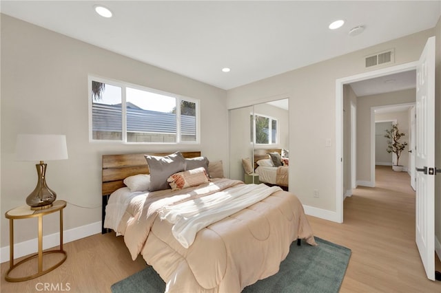 bedroom with baseboards, light wood-style flooring, visible vents, and recessed lighting