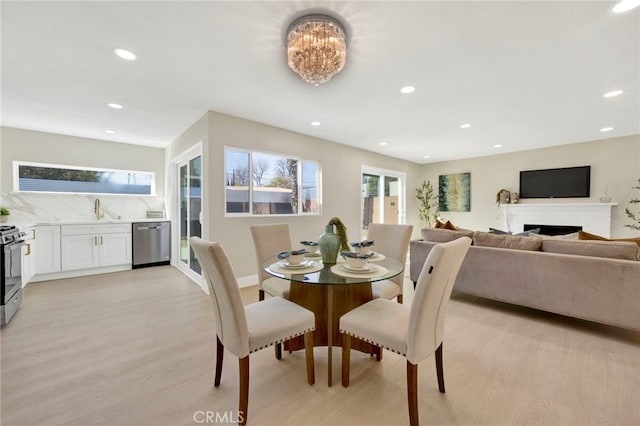 dining space with light wood finished floors, a wealth of natural light, and recessed lighting