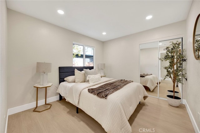 bedroom featuring light wood-type flooring, baseboards, a closet, and recessed lighting