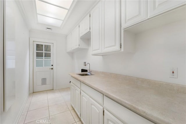 kitchen with white cabinetry, sink, and light tile patterned flooring