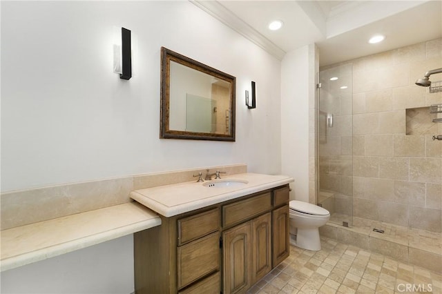 bathroom featuring vanity, tiled shower, and toilet