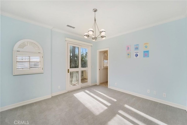 carpeted empty room featuring crown molding, a wealth of natural light, and a chandelier