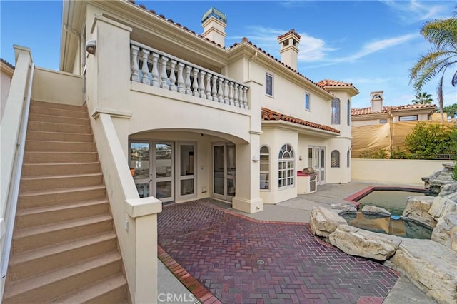 back of property with a balcony and a patio