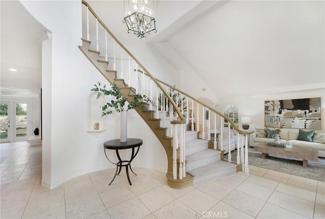 stairs with tile patterned flooring, a notable chandelier, and high vaulted ceiling