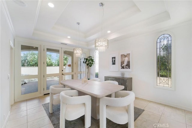 tiled dining room with french doors, ornamental molding, and a raised ceiling