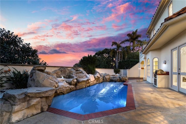 pool at dusk with a patio