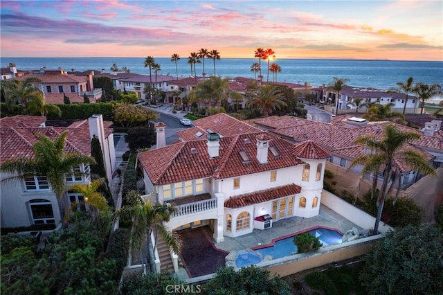 aerial view at dusk featuring a water view