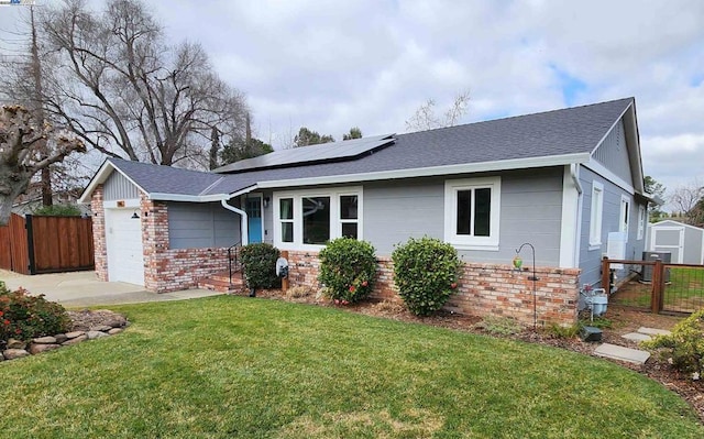 ranch-style house featuring a garage, a front yard, and solar panels