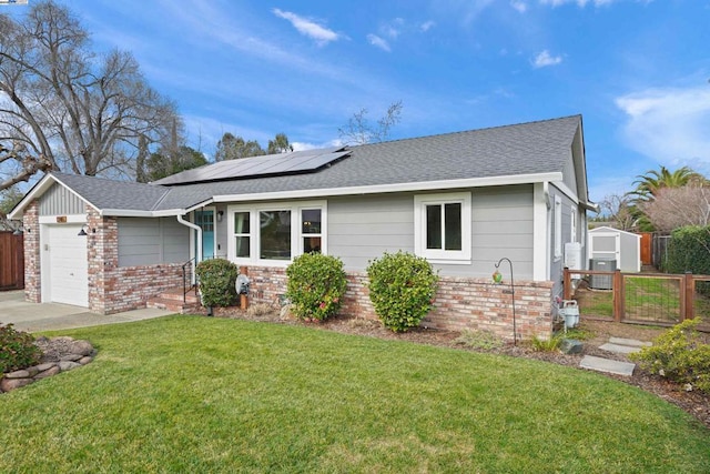 ranch-style house featuring a garage, a front yard, and solar panels