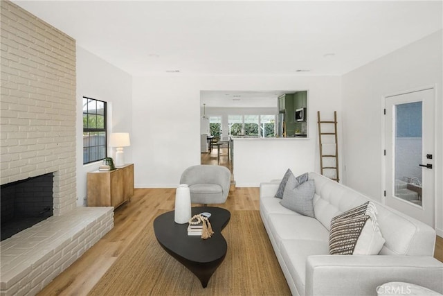 living room featuring light wood-type flooring and a fireplace