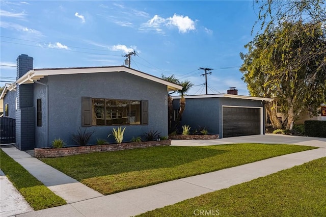 view of front of home with a garage, an outdoor structure, and a front yard