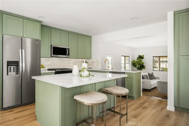 kitchen with appliances with stainless steel finishes, sink, and green cabinets