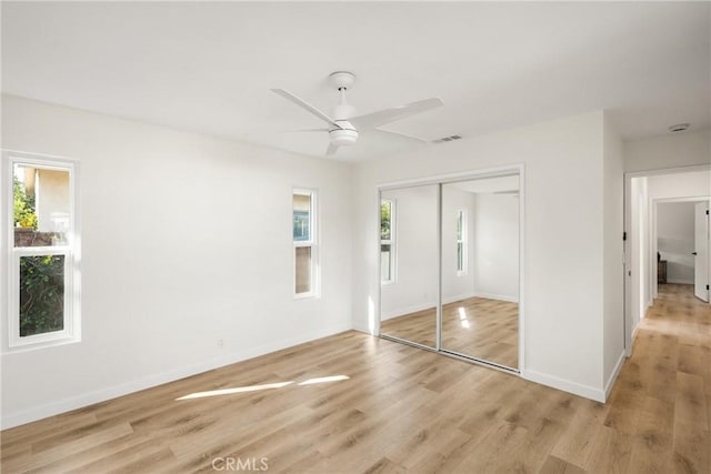 unfurnished bedroom featuring ceiling fan, light wood-type flooring, and a closet